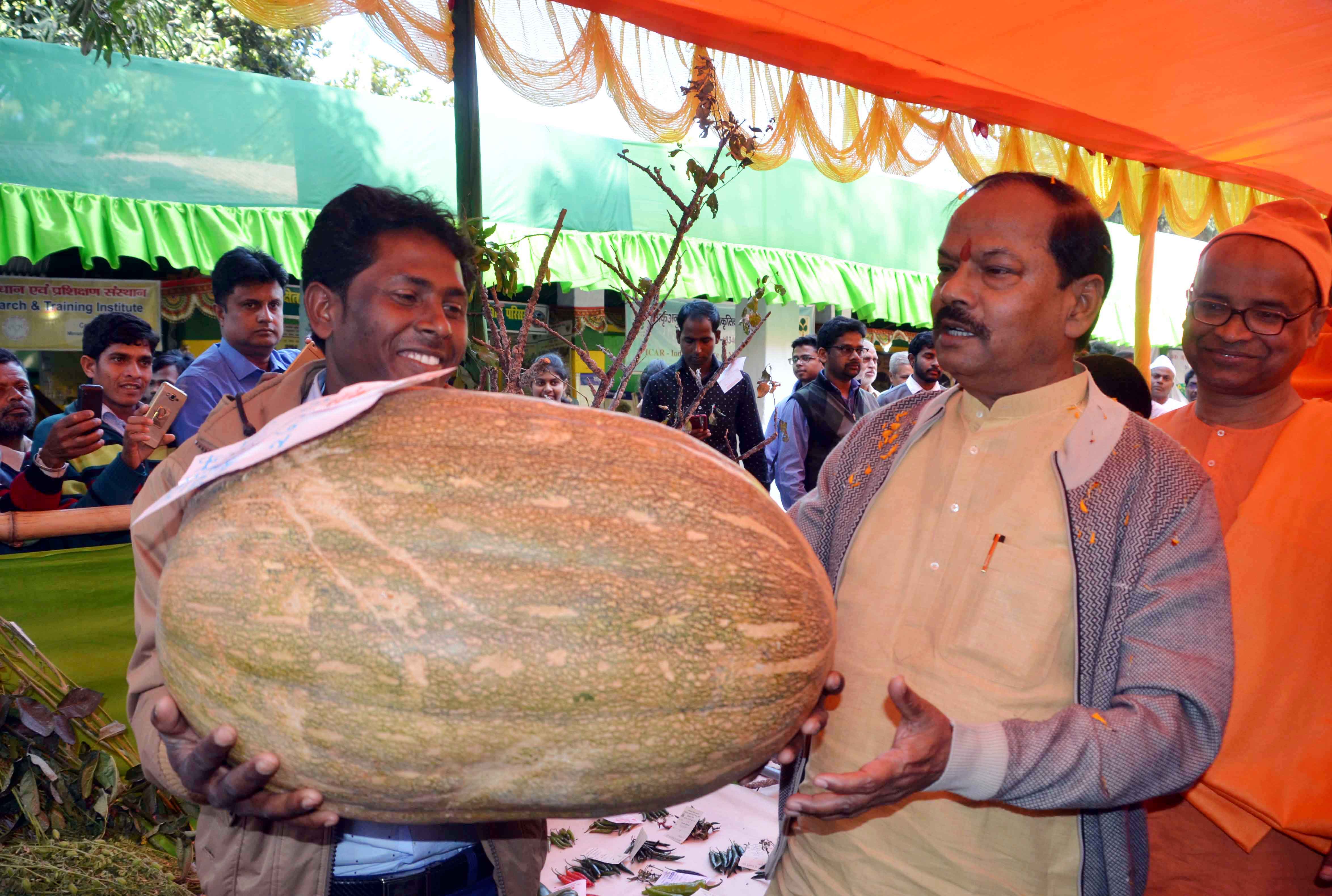 <p>A farmer showing a huge pumpkin to Chief Minister Raghubar Das during inaugural ceremony of '40th National Ramakrishna Kishan Mela' at Getulsudh village under Angara block…