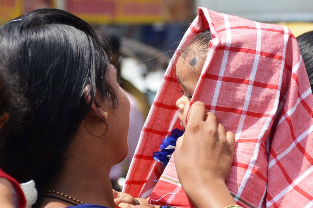<p>A mother protects her child from the scorching sun with a small towel in Ranchi on Wednesday.</p>
