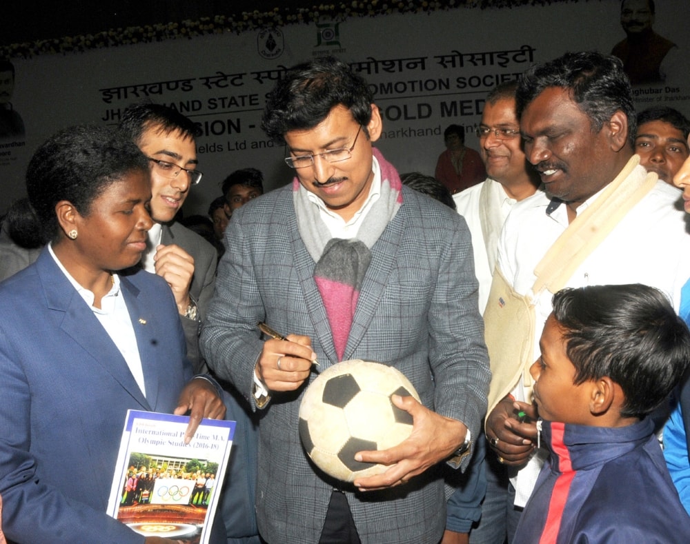 <p>Union Minister of youth Affairs and Sports Rajyavardhan Singh Rathore gives his autograph on a football to a boy during the sports programme on ''Our Mission-Olympic Gold…