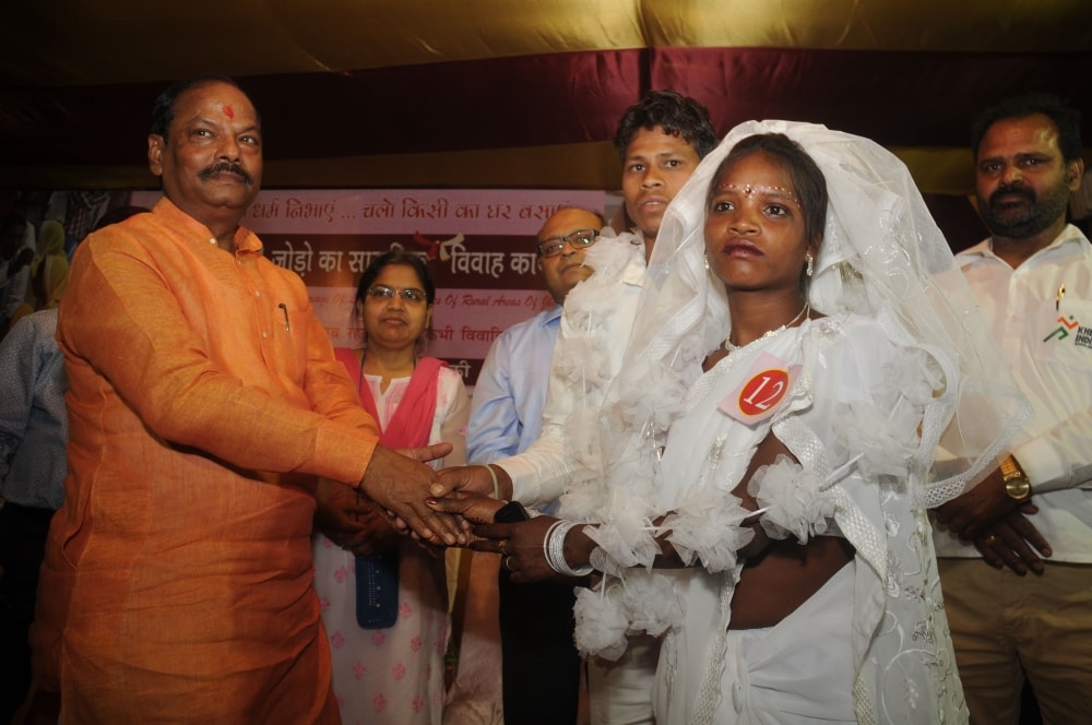 <p>Jharkhand Chief Minister Raghubar Das greets a newly married couple at JAP ground in Ranchi on Saturday. Around 51 poor tribal couples took part in the mass marriage ceremony.</p>…